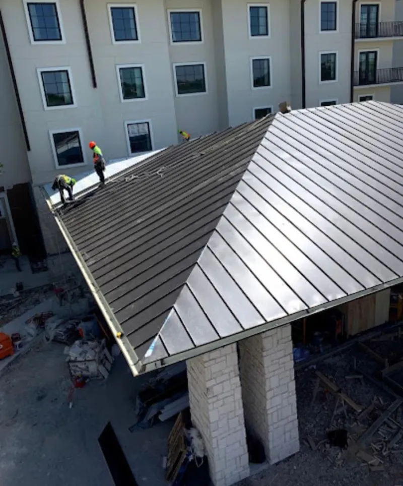 Crew installing standing seam metal roof panels on a commercial project in Potomac Mills